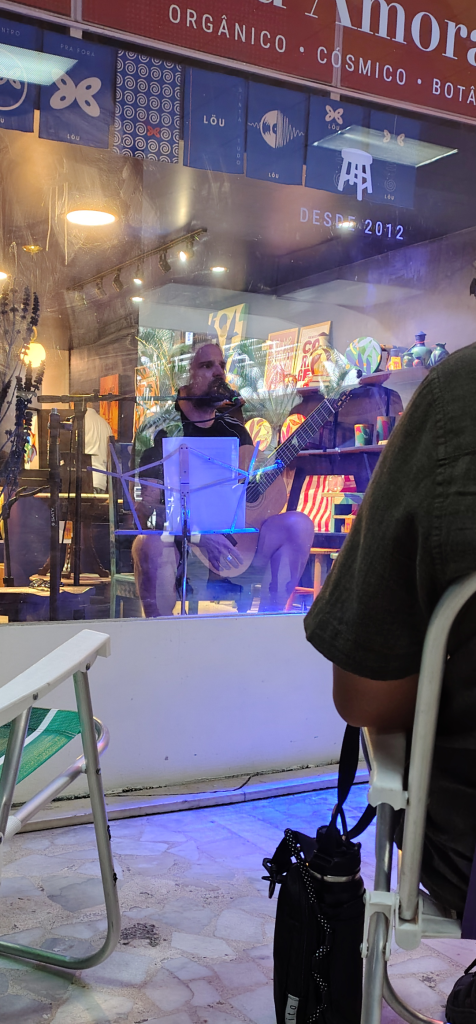 Andreas Kisser tocando atrás de uma vitrine